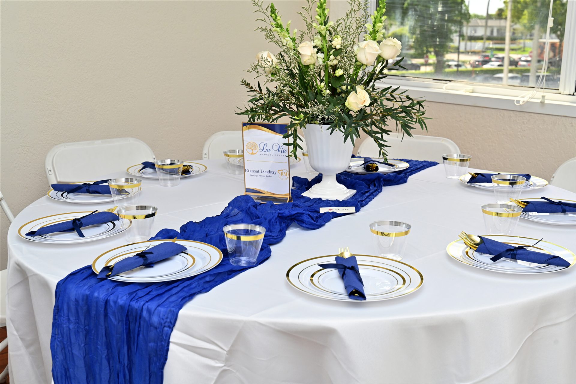 Mesa de invitados vestida en azul, blanco y dorado